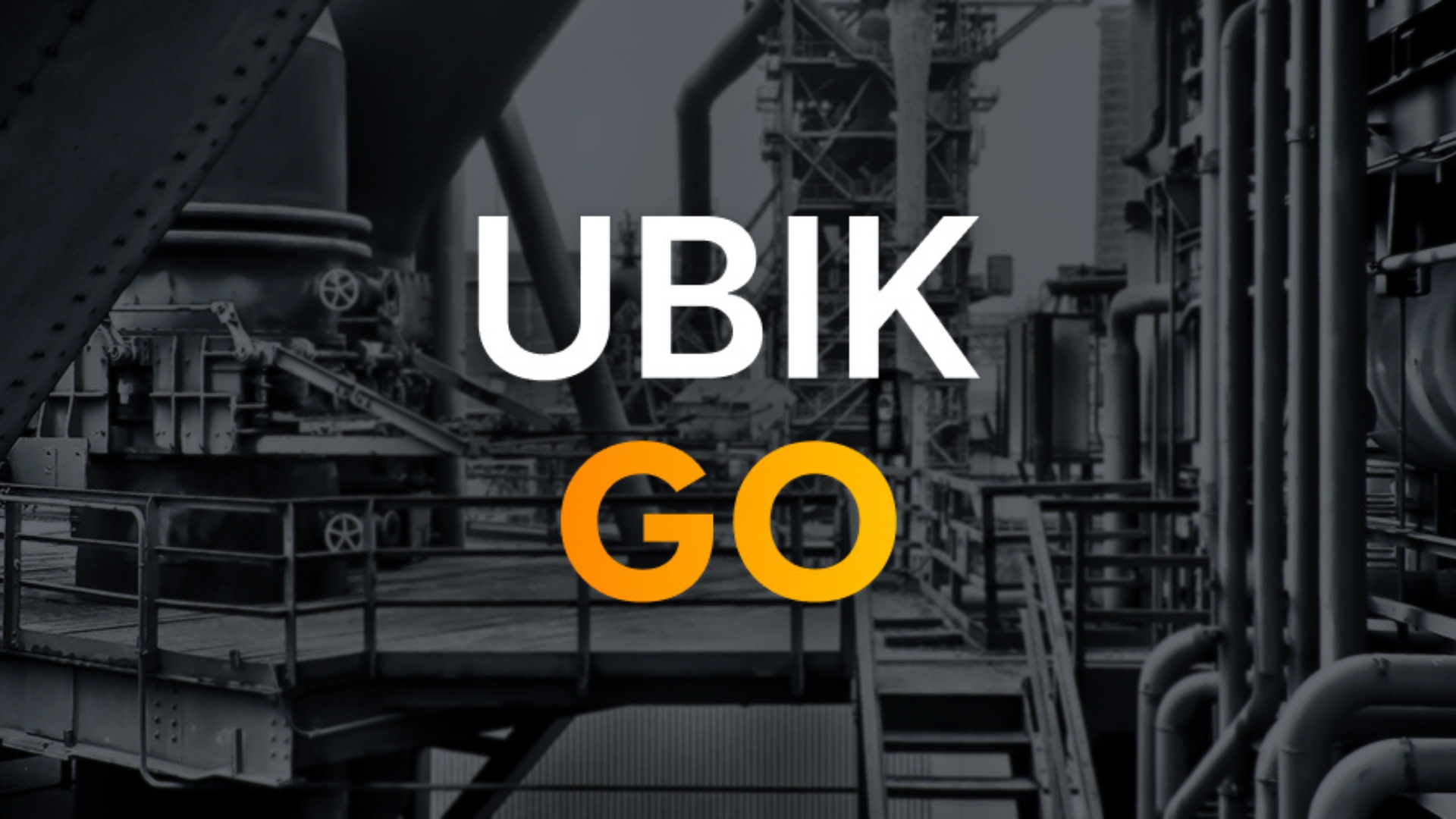 The written UBIK GO logo is visible in the middle of the picture. In the background are pipes of an industrial plant in black and white.